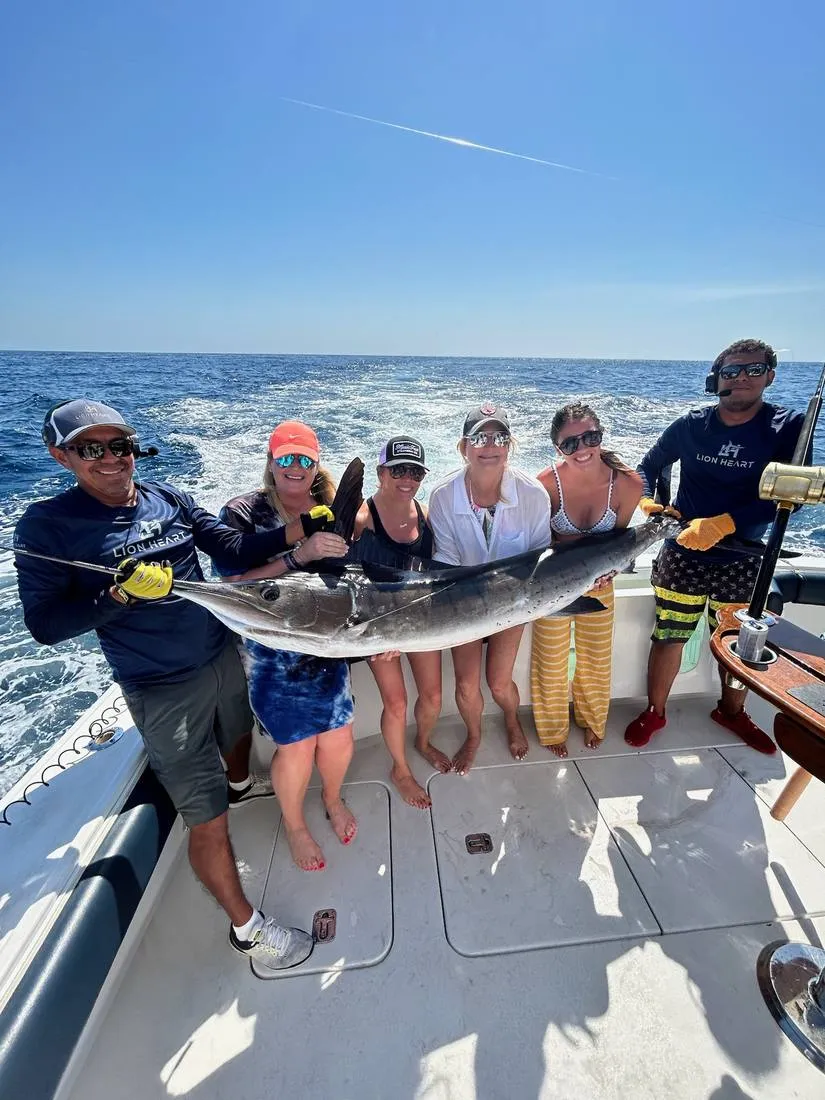 Women anglers with Lion Heart crew holding large catch offshore Cabo San Lucas