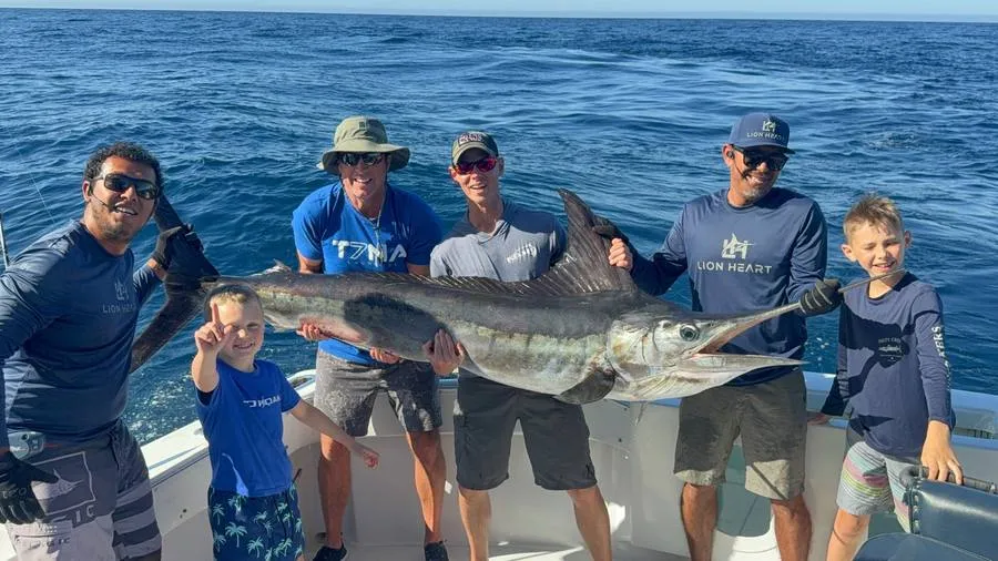 Happy guests on full day fishing charter with trophy striped marlin aboard Lion Heart Cabo San Lucas